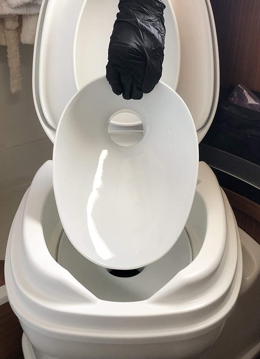 Ein weißer TWUSCH Porzellaneinsatz wird in eine Campingtoilette eingesetzt
